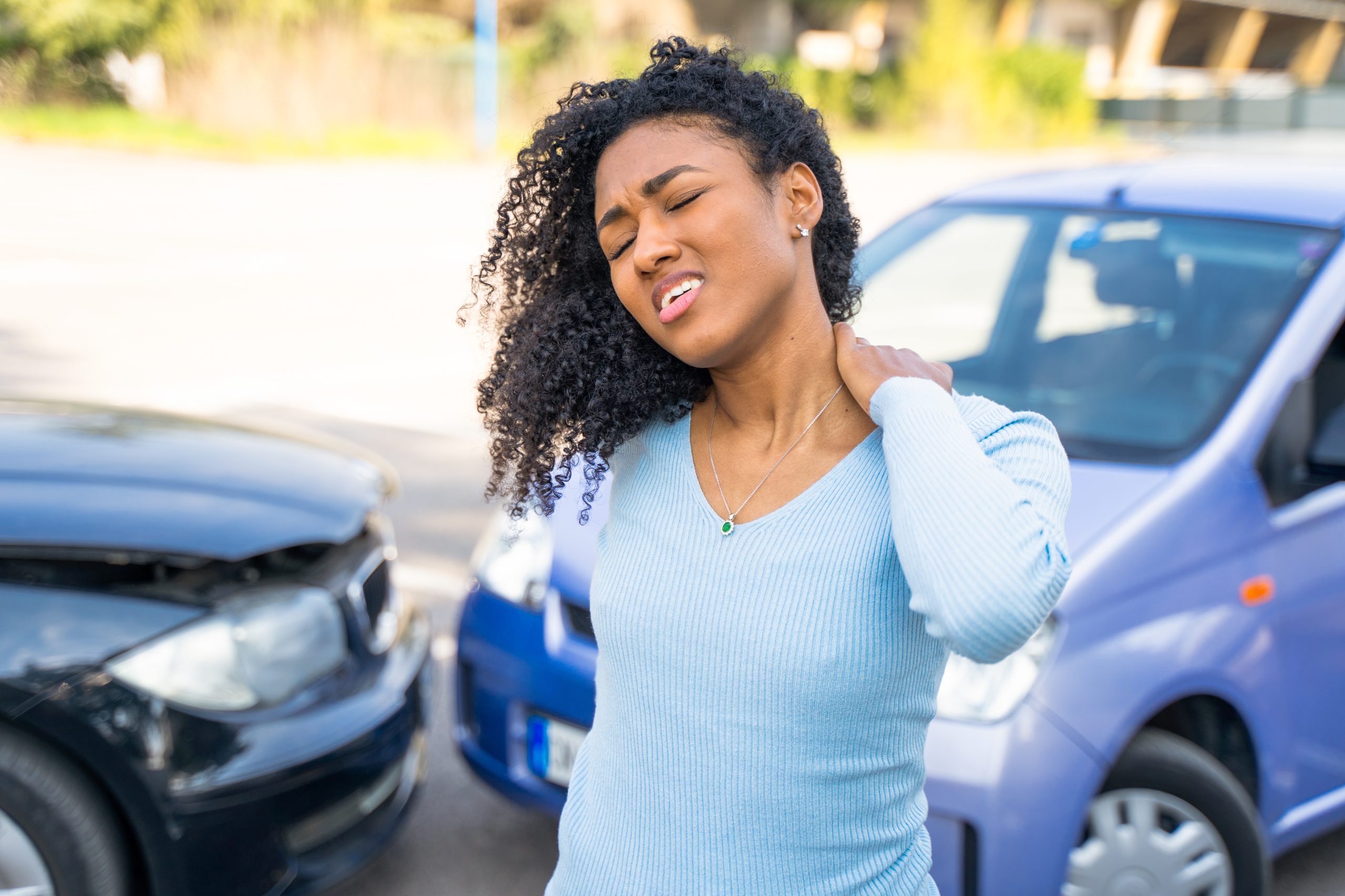 Woman experiencing neck pain after a car accident.